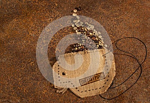 A cup sewn in jute with needle and wire full of coffee beans .