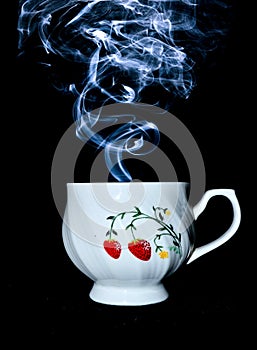 Cup with steam coming on top against a black background