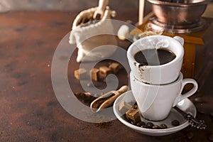 Cup of steaming hot coffee with coffee beans, coffee grinder, and coffee beans bag