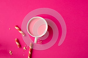 Cup of strawberry and sweet cookies on pink background