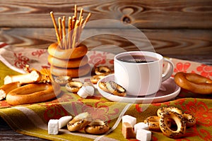 A cup of strong black tea with bagels, sugar, poppy sushki