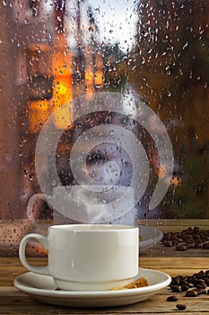 Cup of strong coffee on the rainy window background