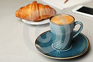 Cup of tasty aromatic coffee and croissant. Space for text
