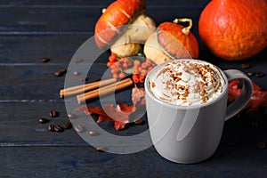 Cup with tasty pumpkin spice latte on blue table