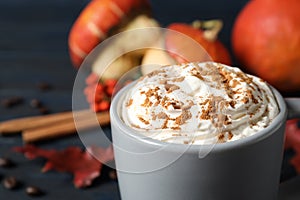 Cup with tasty pumpkin spice latte on blue wooden table