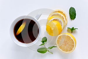 A cup of tea along with mint and lemon. Tea for colds. Natural cures for the disease. Vitamin C. Black tea with lemon on