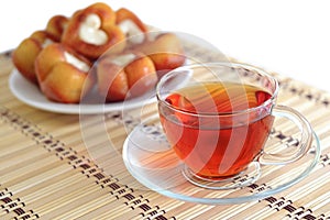 Cup of tea on a background of plate of cakes