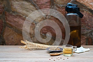 Cup of tea, barley grains and ears of rice on wooden background