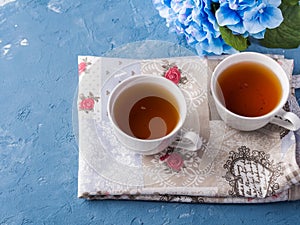 Cup of tea on blue background with flowers
