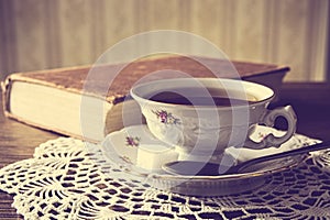 Cup of tea with book on napkin vintage effect