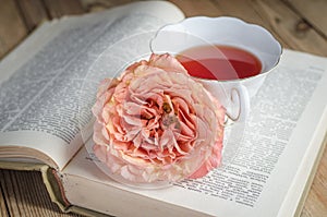 Cup of tea, a book and a rose