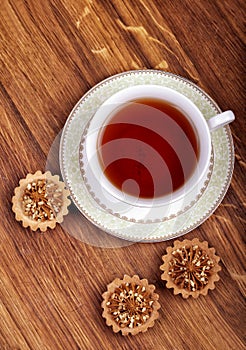 Cup of tea with cakes on a wooden background