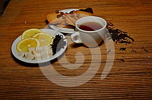 A cup of tea candy lemon cookies on a plate near the tea dumped white black green copy space