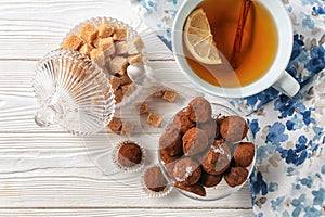 Cup of tea with chocolate truffles on light table