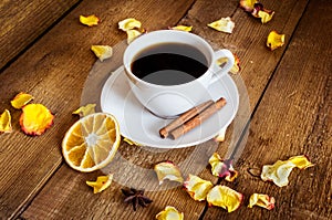 Cup of tea, dried orange, dried yellow rose petals on wooden background