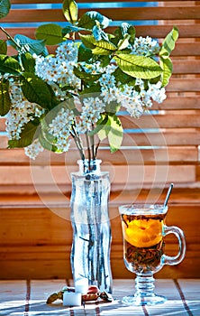 Cup of tea with emon and cherry on wooden background. Window photo