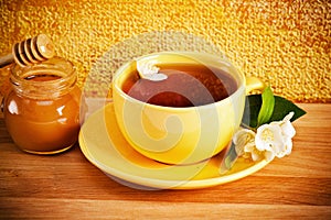 Cup of tea with flower of a jasmin and honey