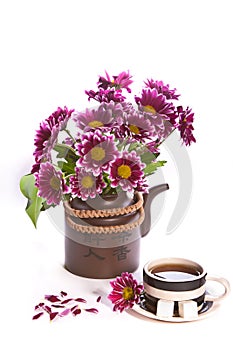 Cup of tea and flowers in a teapot