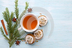 A cup of tea with fragrant honey Christmas gingerbreads with glaze and nuts, with Christmas tree branches and spices