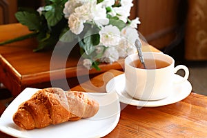 Cup of tea with french croissant