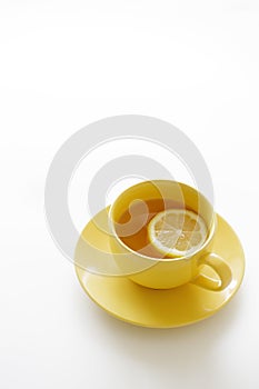 Cup of tea with fresh yellow lemons on white background