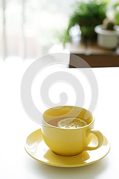 Cup of tea with fresh yellow lemons on white background