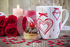 Cup of tea in front of bouquet of red roses