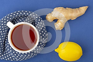 Cup of tea, ginger, lemon as folk remedies on blue background  with copy space for text. The concept of seasonal diseases and