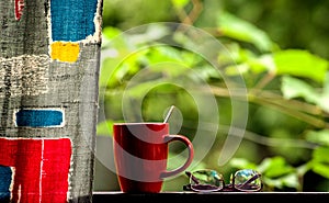 A cup of tea and glasses on the open terrace on the background of nature