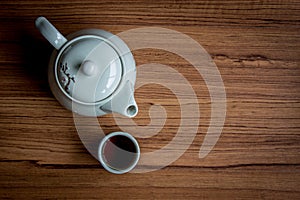 A cup of tea and kettle on rustic wood background