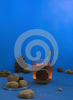 Cup of tea with lemon on a blue background night book cookie candle heart