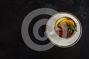 Cup of tea with lemon and brown sugar, cinnamon and anise on the table