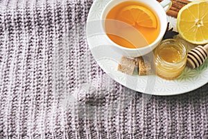 Cup of tea with lemon and cookies, honey and cinnamon sticks, star anise on the blanket.. Christmas, winter concept