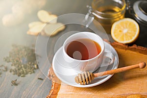 Cup of tea with lemon, ginger, honey and honey stick on wooden rustic table