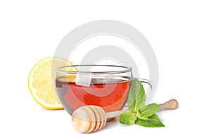 Cup of tea, lemon, mint and dipper isolated on white