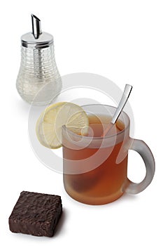 A cup of tea with lemon, sugar and chocolate