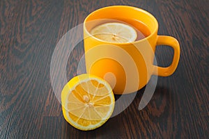 Cup of tea with lemon on table close-up. healthcare, traditional medicine and flu concept - tea cup with lemon.
