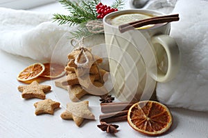 A Cup of tea with lemon on the table close-up surrounded by Christmas decorations and homemade cakes.