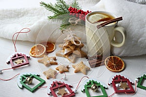 A Cup of tea with lemon on the table close-up surrounded by Christmas decorations and homemade cakes.