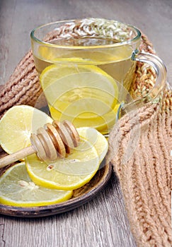 Cup of tea with lemon and a warm scarf. vitamin tea. cold and flu remedy.