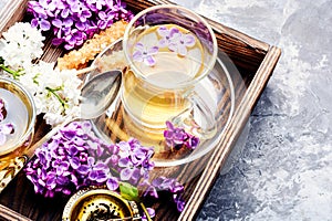 Cup of tea and lilac flowers