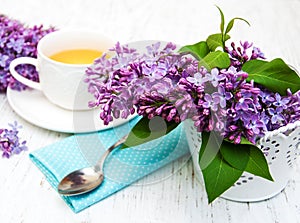 Cup of tea and lilac flowers