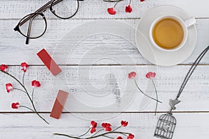 A cup of tea, lipsticks, necklace and eyeglasses