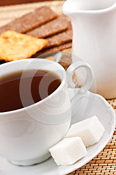 Cup of tea with a lump sugar and crackers
