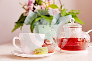 Cup of tea with macaroons. Herbal natural raspberry tea time at aesthetic home. Cozy home, self care, wellness lifestyle