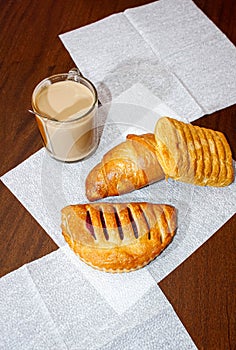 A Cup of tea with milk and various pastries on the table during tea