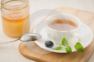 Cup with tea and mint with blueerry and honey/cup with tea and mint with blueberry and honey. selective focus