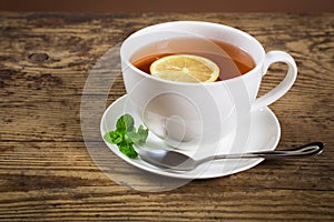 Cup of tea with mint leaf and lemon