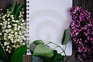 a Cup of tea, nuts, lilacs and a notebook on a wooden table