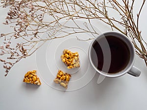 Cup of tea, peanut kozinak and dried flowers on a white background